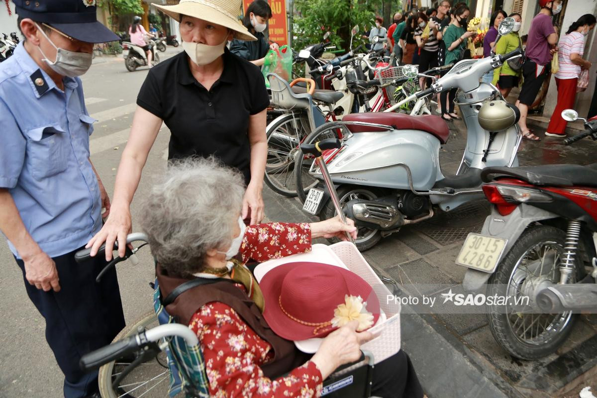 Cụ bà 90 tuổi ở Hà Nội ngồi xe lăn xếp hàng từ sớm chờ 2 giờ mua bánh ngày Tết Hàn Thực Ảnh 14