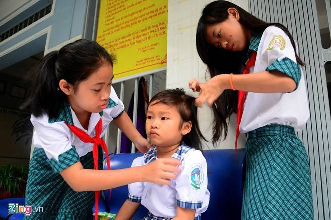 Bé Huyền (chị của Thoại) được các chị lớn trong trung tâm tết tóc, sửa trang phục. Hai chị em Huyền (6 tuổi) và Thoại (5 tuổi), con của anh Trần Anh Tuấn, trước đây làm nghề dán keo xe, điện thoại bên đường Nguyễn Hữu Thọ, quận 7. Câu chuyện về hai em từng sống lề đường hơn một năm trước gây xôn xao, thu hút sự quan tâm của nhiều người.