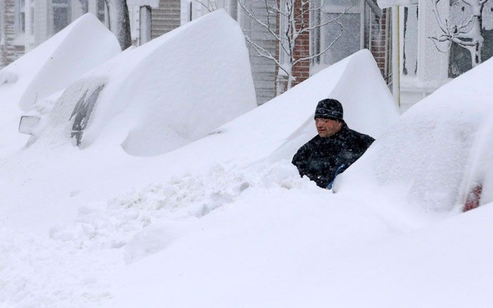 14 jonas John Silver shovels snow between buried cars in front of his home on Third Street in South Boston