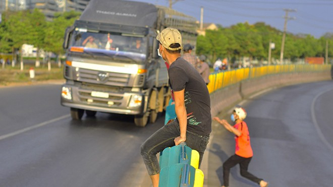 Công nhân liều mạng trèo dải phân cách trước đầu xe tải Ảnh 2