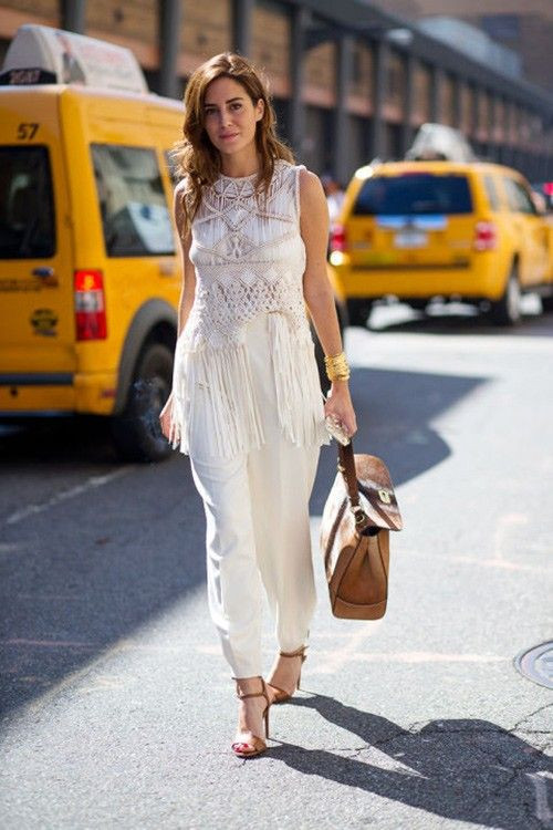 Một chiếc áo tua rua trắng đậm chất boho được kiềm lại bằng quần âu cùng màu và phụ kiện màu da bê.