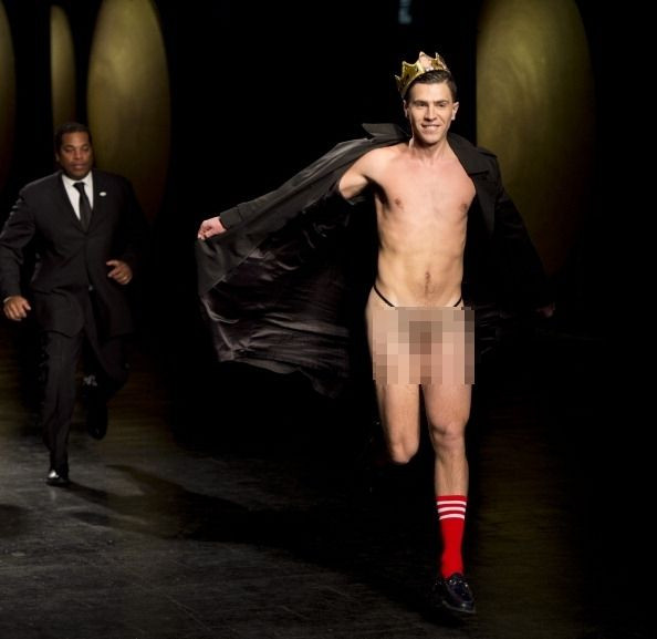 A flasher runs from security guards during as show of designs by Prabal Gurung during the Mercedes-Benz Fashion Week Fall/Winter 2014 shows ON February 8, 2014 in New York. AFP PHOTO/Don Emmert (Photo credit should read DON EMMERT/AFP/Getty Images)