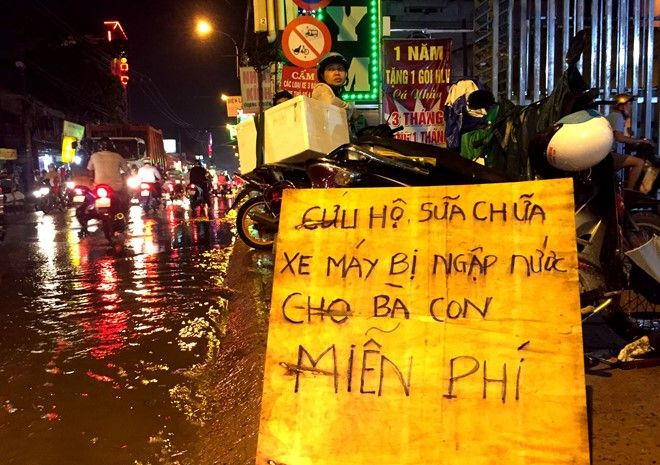 Bảng thông báo sửa xe miễn phí đặt ngay trên vỉa hè. Ảnh: Lê Trai.