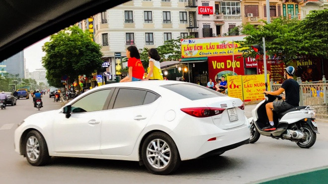 Clip: Hai bé gái vô tư ngồi chơi trên nóc ô tô đang chạy giữa phố Hà Nội Ảnh 2