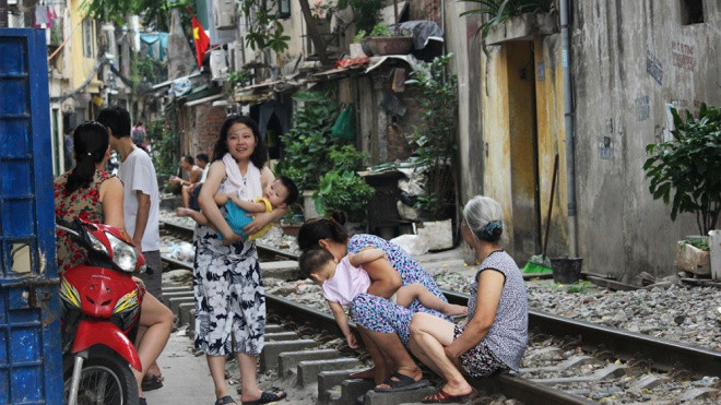 Thản nhiên bế cháu ngồi trên đường ray tán gẫu, thách thức tử thần Ảnh 2