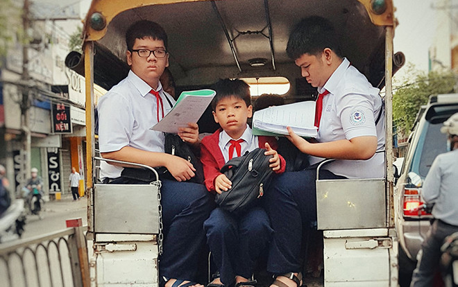 Bức ảnh chụp 3 cậu học sinh tranh thủ học vội đầy căng thẳng trên đường đến trường khiến ai cũng phải suy nghĩ Ảnh 2