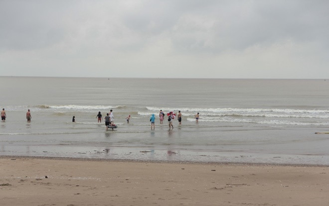 Bất chấp thời tiết mưa gió trước khi bão số 3 đổ bộ, nhiều du khách vẫn ra biển chơi đùa Ảnh 2