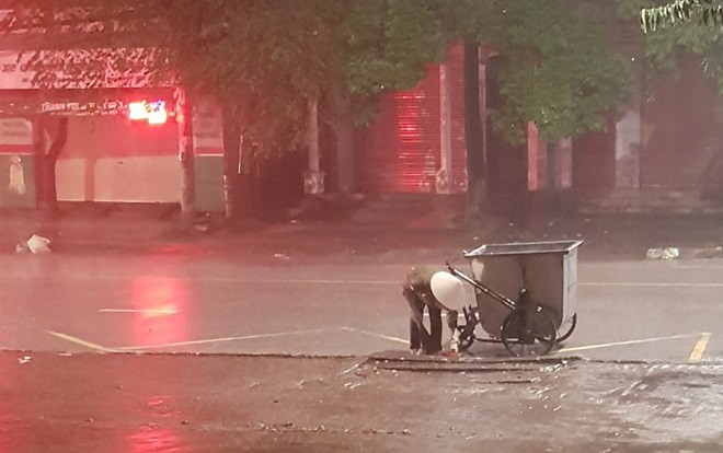 Xúc động khoảnh khắc cô lao công cặm cụi dọn rác cho khỏi tắc cống dưới trời mưa lớn trong đêm Ảnh 2