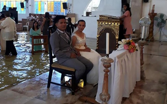Bất chấp mưa bão xối xả, cặp đôi đi thuyền tới nhà thờ ngập nước để tổ chức đám cưới Ảnh 2