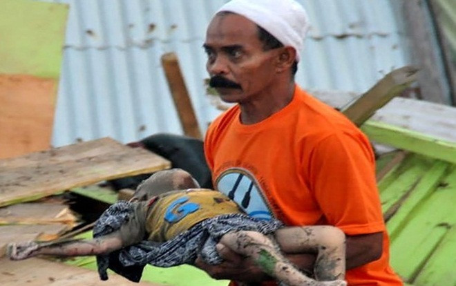 Nhà cửa đổ nát, hố chôn tập thể dài 100 m cùng những hình ảnh cho thấy mức độ tàn phá khủng khiếp của động đất, sóng thần ở Indonesia Ảnh 2