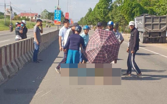 Người dân dùng ô che nắng cho thi thể nam dân quân tự vệ sau cú tông vào dải phân cách tử vong Ảnh 2