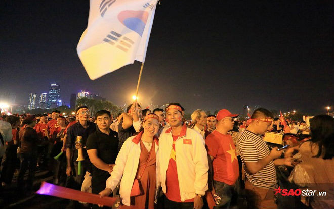 Giữa rừng cờ đỏ sao vàng, cặp vợ chồng mang cờ Hàn Quốc đi cổ vũ đội tuyển Việt Nam và lí do gây bất ngờ Ảnh 2