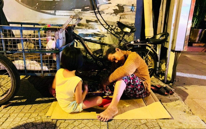 Mặc dòng người xuống đường đi bão, hình ảnh bà cháu co ro ôm nhau ngủ sau mưu sinh khiến cộng đồng mạng xúc động Ảnh 2