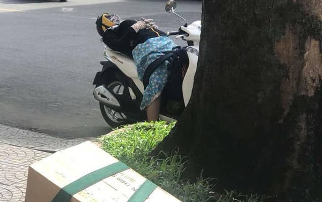 Quá mệt vì 'vật lộn' với nắng nóng gay gắt, người phụ nữ trùm kín như ninja ngả lưng trên xe SH ngủ bên lề đường Ảnh 2