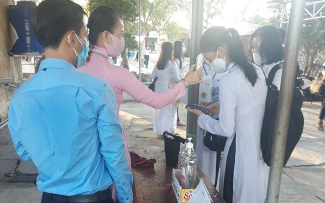 Học sinh ở Cà Mau ngồi cách nhau 2m, đeo khẩu trang trong lớp vào ngày đầu trở lại trường Ảnh 2