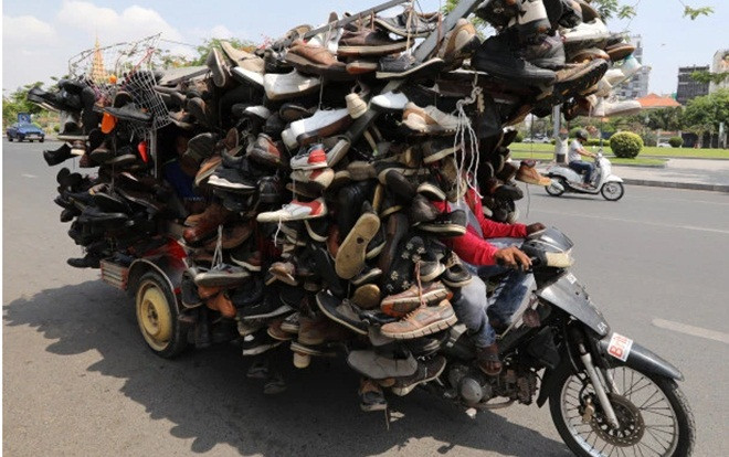 Người đàn ông chở hàng trăm đôi dép cồng kềnh trên xe máy Ảnh 2