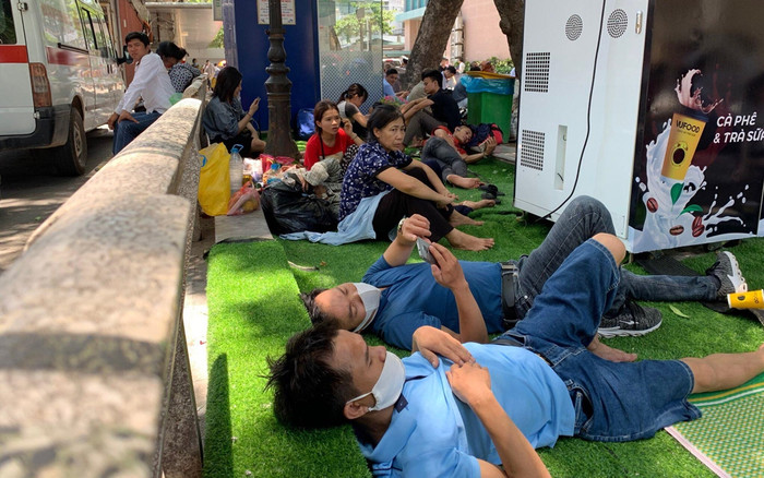 Chùm ảnh: Người thân bệnh nhân vật vờ ngoài hành lang bệnh viện Bạch Mai dưới cái nóng 40 độ Ảnh 2