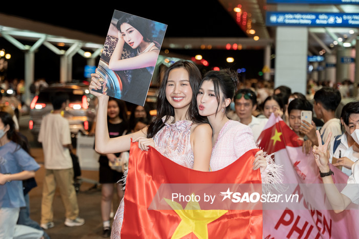Á hậu Bảo Ngọc diện thiết kế váy lụa cổ yếm có sắc hồng trong trẻo. Cô là người đầu tiên đến sân bay để chào tạm biệt người em 'Candy Bông' Phương Nhi. 