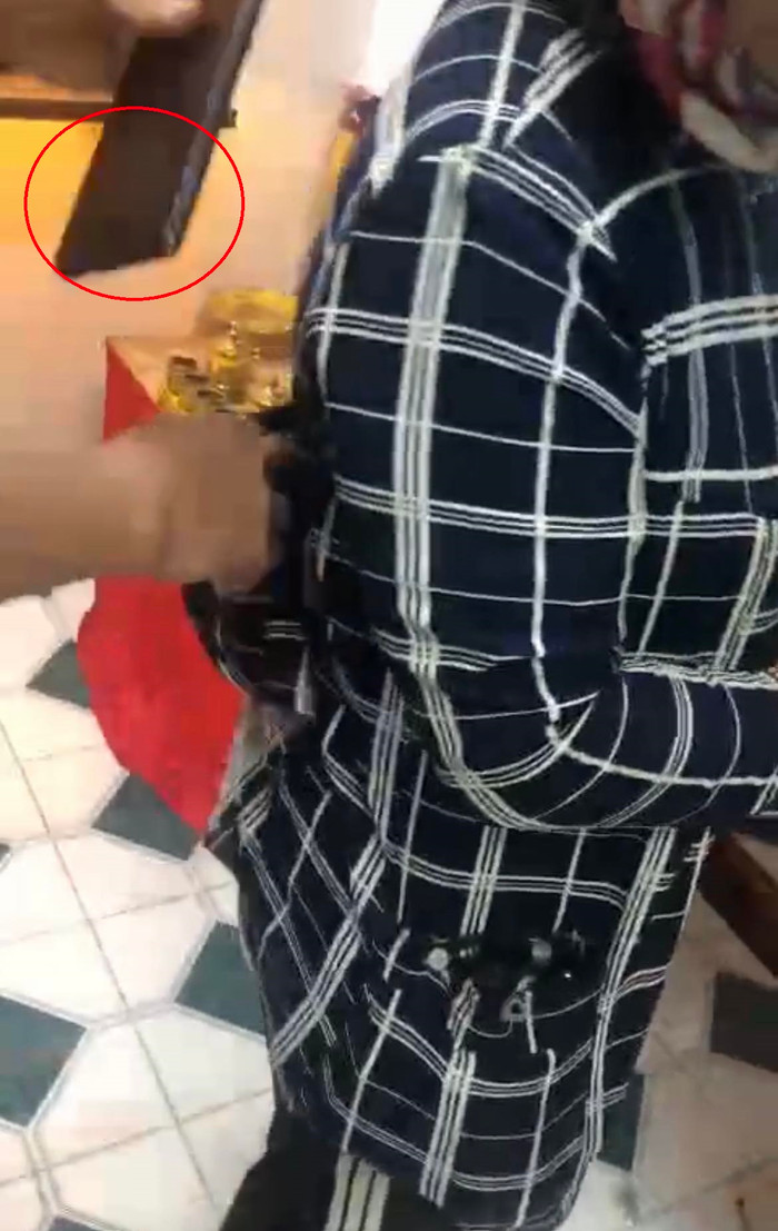 Chủ tiệm đành phải tiến tới, tự mình lôi chiếc điện thoại từ trong túi áo người phụ nữ ra, lấy lại tài sản.