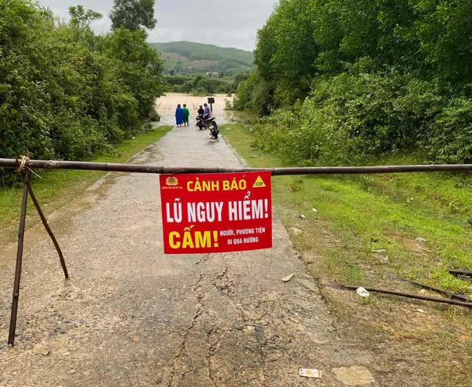 Lực lượng chức năng lập rào chắn, treo biển cảnh báo cấm người dân qua lại khu vực bị ngập. Ảnh: Người Lao Động