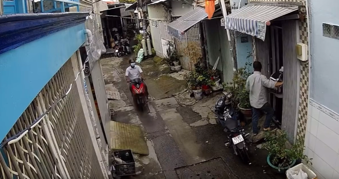 Sau khi giật được điện thoại trên tay bé trai, gã đàn ông liền điều khiển xe máy rời đi. Ảnh cắt từ clip