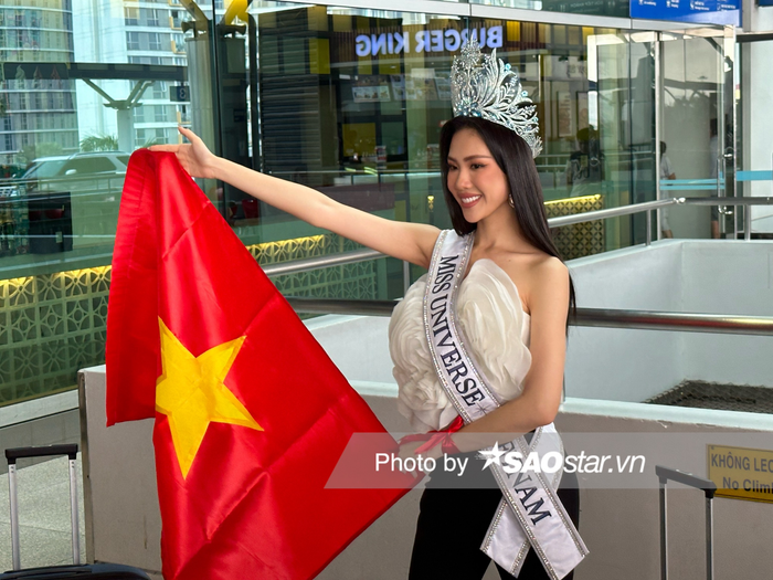 Tại sân bay, Miss Universe Vietnam 2023 diện set đồ trắng đen có hình hoa nổi bản lớn trước ngực và để tóc thẳng dài. Ngoài ra, cô không quên mang theo vương miện giúp bản thân nổi bật trước đám đông. 