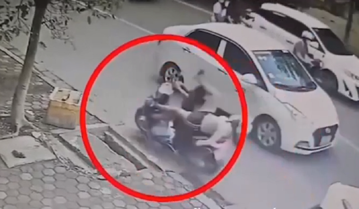 Bé trai bất ngờ vặn tay ga khiến chiếc xe lao vút đi, hậu quả khiến 2 mẹ con ngã nhào xuống đường khá đau đớn. Ảnh cắt từ clip