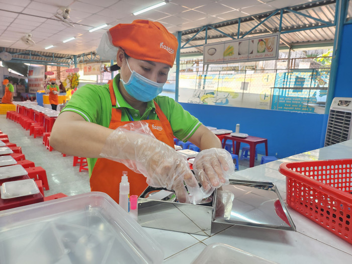 Nhân viên công ty cung cấp suất ăn bán trú đang lưu mẫu thức ăn tại Trường Tiểu học Phước Thạnh, TP Thủ Đức. Ảnh: NGUYỄN QUYÊN