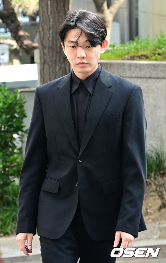 Yoo Ah In mặc trang phục màu đen khi có mặt tại đồn cảnh sát (Ảnh: OSEN)
