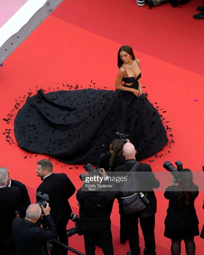 Cựu Hoa hậu Quốc tế lựa chọn chiếc đầm đen hai dây bồng bềnh được đính lông khắp trên tùng váy. Ở phần eo được cắt khoét hai bên để tạo thêm độ gợi cảm cho tổng thể. Kylie Verzosa quyết định xõa tóc dịu dàng và kết hợp thêm một chiếc vòng cổ được nạm chi chít kim cương. 