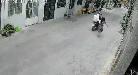 2 thanh niên đi xe máy tiếp cận người phụ nữ và nhanh tay giật chiếc túi xách. Ảnh cắt từ clip