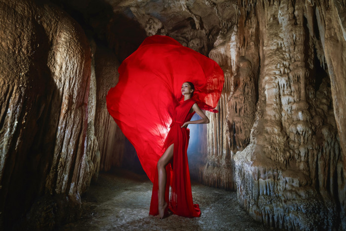 Cô chọn váy màu đỏ của NTK Lê Thanh Hòa có form dáng xẻ tà, chất liệu mỏng, nhẹ dễ tạo hiệu ứng bay bổng. H'Hen Niê tạo những dáng đơn giản nhưng nổi bật được trang phục tà bay, hòa quyện vào khung cảnh hùng vĩ với những khối thạch nhũ tuyệt đẹp.