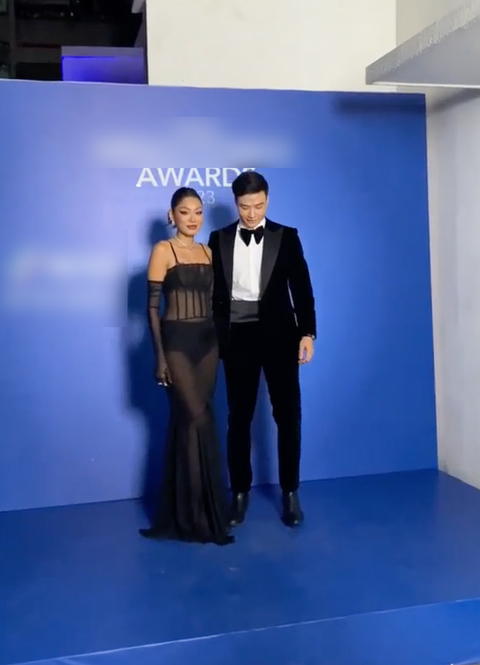 Diện mạo gợi cảm của mỹ nhân sinh năm 1994 được kết hợp bởi một chiếc váy dài quây cúp ngực có chất liệu mỏng màu đen, bên trong người đẹp diện nội y 'ton-sur-tone' để lộ nhiều centimet da thịt. Thảo Nhi Lê bắt kịp xu hướng và không quên đeo thêm một đôi găng tay.  