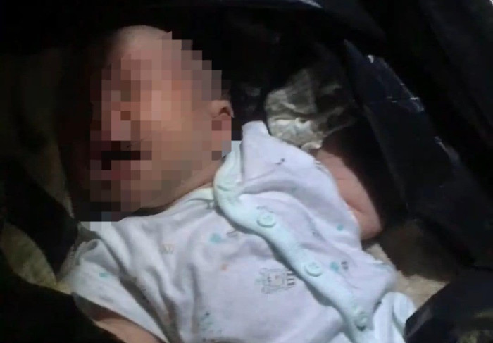 Thời điểm phát hiện ra cháu bé nằm trong bọc nilong màu đen. (Ảnh: VietNamNet) 