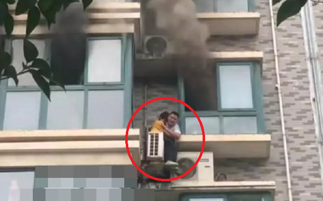 Người đàn ông liều lĩnh trèo qua cửa cứu bé gái mắc kẹt trong tòa nhà bốc cháy Ảnh 2