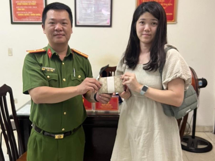 Cơ quan chức năng trao trả lại tài sản cho người đánh rơi. (Ảnh: CAHN).