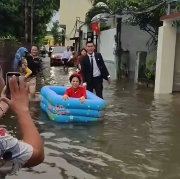 Đám cưới mùa mưa: Cô dâu cười tít mắt ngồi phao trẻ em để chồng rước về dinh Ảnh 1