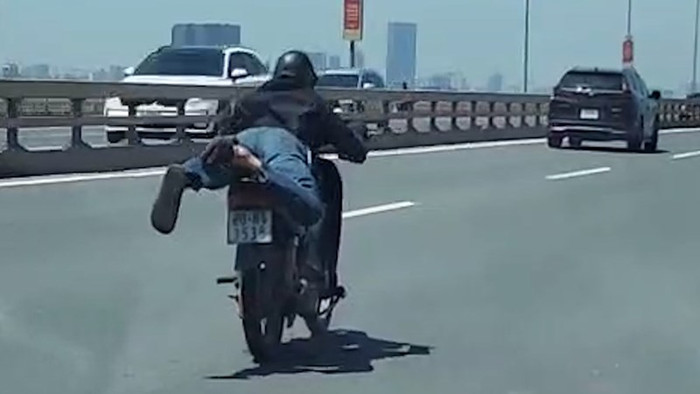 Nam thanh niên nằm dài trên xe máy rồi 'làm xiếc' trên cầu Nhật Tân Ảnh 1