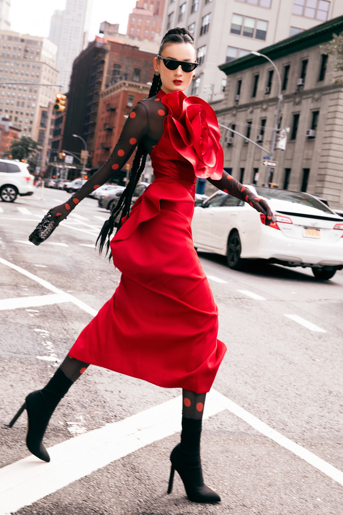 Người mẫu Lê Thúy diện bodysuit, phối cùng váy hoa 3D bên ngoài. Cô mang giày boots, phối cùng túi Chanel đen đồng điệu. 