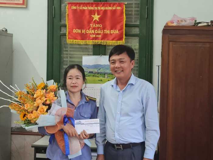 Lãnh đạo Tổng công ty Đường sắt Việt Nam khen thưởng nữ nhân viên gác chắn Phạm Thị Hường vào chiều 1/9. Ảnh: KTĐT