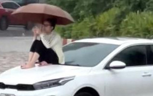 Ô tô chôn chân giữa biển nước, cô gái leo lên nóc capo ngồi ngắm cảnh Ảnh 2