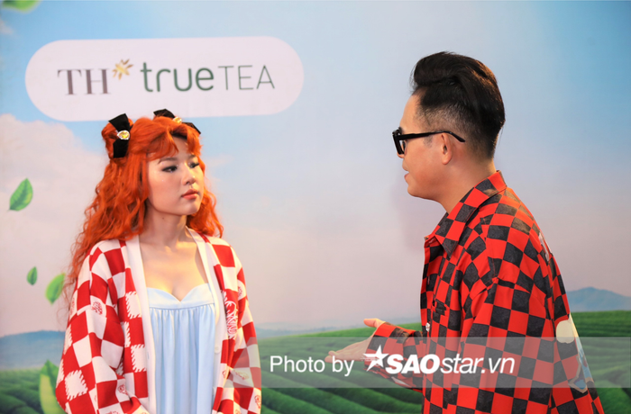 Trong hậu trường liveshow 4 Vietnam Idol, Lamoon nhuộm tóc đỏ cam nổi bần bật, mặc đồ trẻ trung và lắng nghe, trò chuyện với MC Đức Bảo