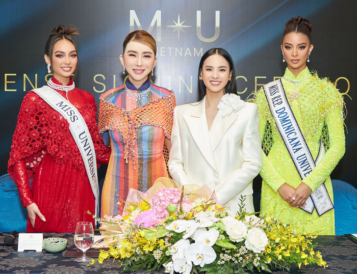 Hình ảnh Quỳnh Nga (áo trắng) trong buổi ký kết với bà chủ Miss Universe - Anne jakrajutatip và Top 3 Hoa hậu Hoàn vũ 2022 vào tháng 2/2023.