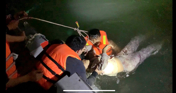 Cơ quan chức năng giải cứu cô gái trên sông. (Ảnh: CAHN).