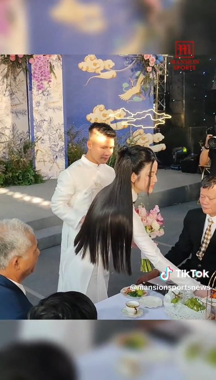 Vợ sắp cưới của Quang Hải mời trà bằng một tay, tay còn lại vẫn cầm hoa khiến cư dân mạng tranh cãi dữ dội. (Ảnh chụp màn hình TikTok mansionsportnews).