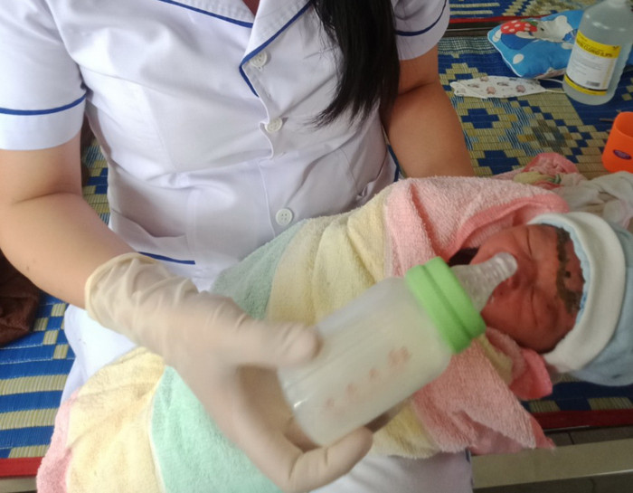 Bé đang được các nhân viên y tế chăm sóc.