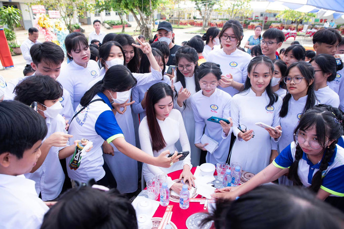 Nam Em vui vẻ cho chữ ký khi tham gia một sự kiện