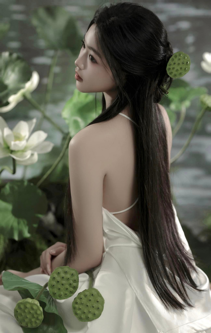 Bên cạnh đó, phần tóc đen dài suôn mượt, được búi nhẹ phía sau đã làm tôn lên khuôn mặt thanh tú, đôi mắt đen sâu thẳm cùng nụ cười mỉm đầy bí ẩn của con gái Quyền Linh.