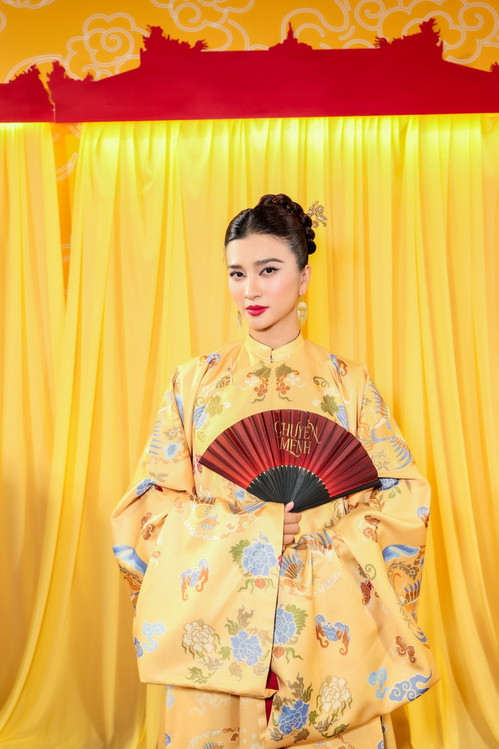 Vợ màn ảnh Lý Hùng - NSƯT Kim Tuyến nổi bần bật khi diện áo dài màu vàng, hoa văn rồng phượng đầy quyền lực. Nữ diễn viên khoe sắc vóc quyến rũ, trẻ trung dù sắp bước sang tuổi 40. Trong thời gian tới, NSƯT Kim Tuyến sẽ đóng cặp với Lý Hùng trong phim điện ảnh mới. Bên cạnh đó, cô cũng sẽ tái xuất màn ảnh VTV trong phim Mẹ Biển.