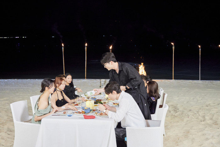 Dàn người chơi tham gia bữa tiệc bên bờ biển.